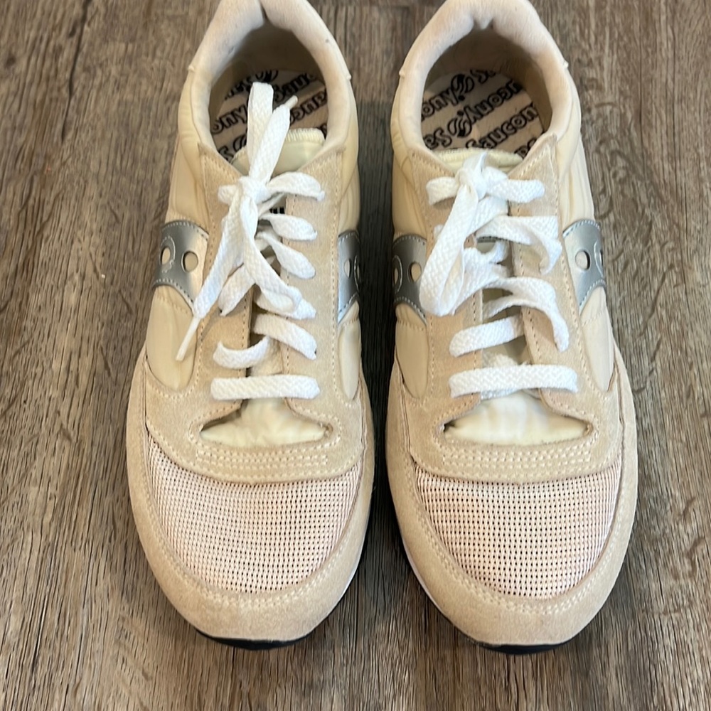 Saucony women off white with a silver line sneakers.